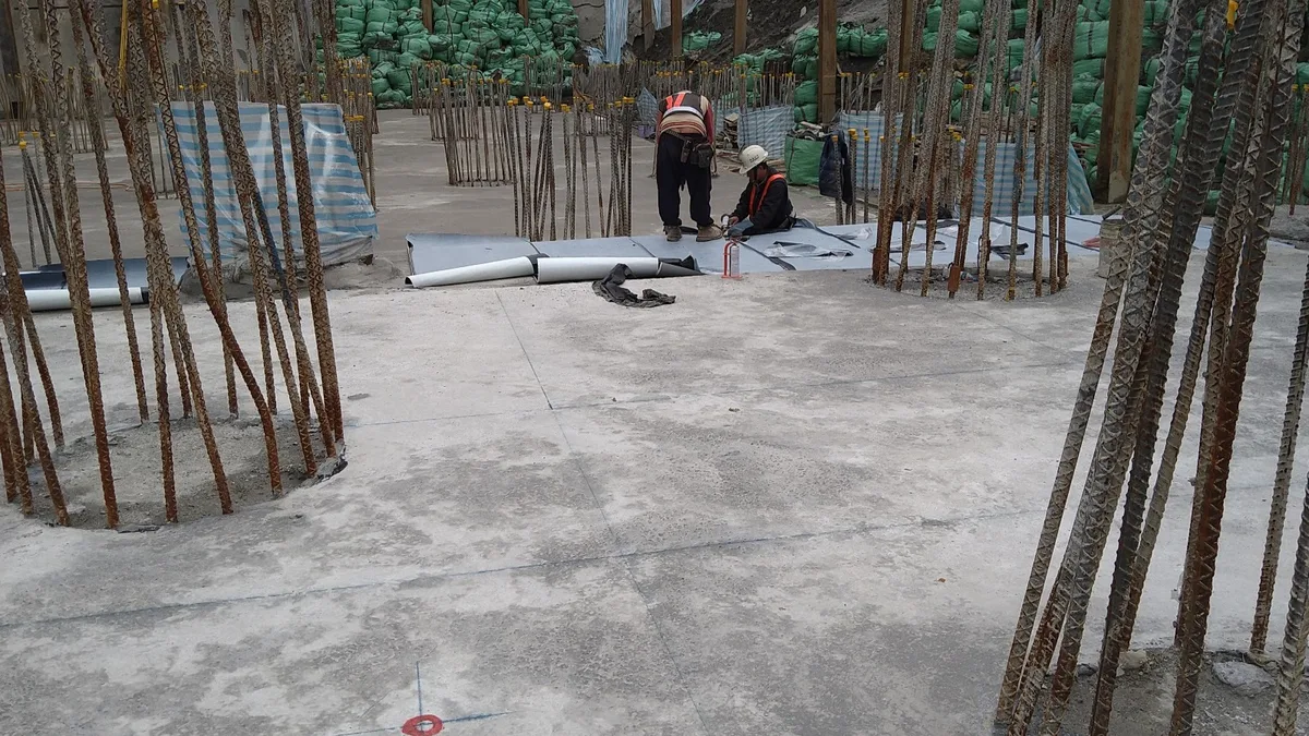 基樁樁頭，工人正在進行底板防水膜鋪設作業